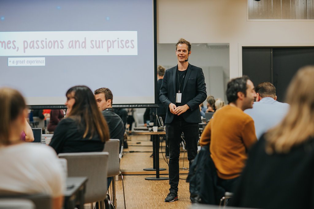 Jarle Kondrup on stage in front of a screen during a keynote